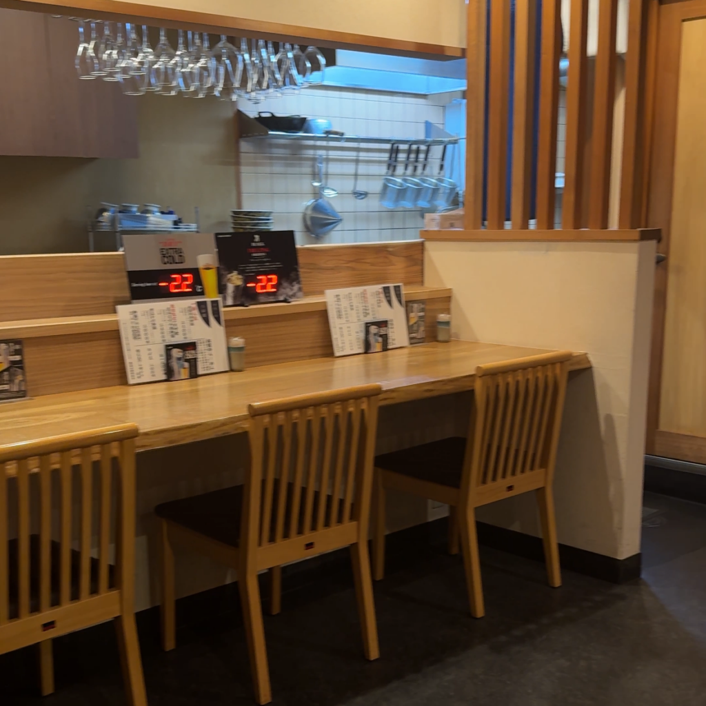 和牛らーめん笑門の落ち着いた木目調カウンター席とキッチンの様子